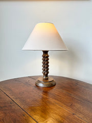 French midcentury table lamp In the style of Charles Dudouyt, c.1930-50

Oak facet carved stem on a turned wood base in a late deco style.