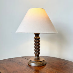 French midcentury table lamp In the style of Charles Dudouyt, c.1930-50

Oak facet carved stem on a turned wood base in a late deco style.