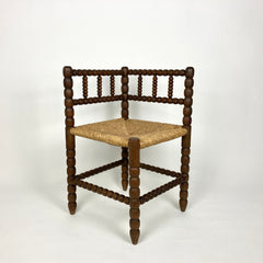 Antique oak bobbin turned corner chair with rush seat.